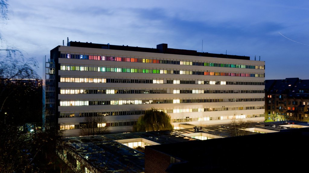  Vue nocturne du b&acirc;timent du BLSI, dont les fen&ecirc;tres &eacute;clair&eacute;es et color&eacute;es se d&eacute;tachent dans le paysage urbain