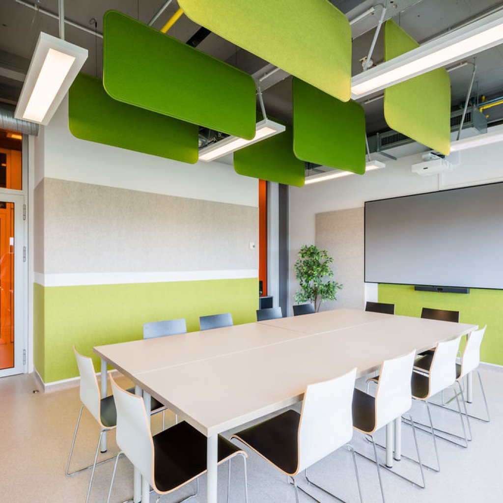 Salle de r&eacute;union du BLSI &agrave; Bruxelles pouvant accueillir jusqu&rsquo;&agrave; quatorze personnes autour d&rsquo;une grande table, &eacute;quip&eacute;e d&rsquo;un &eacute;cran de projection mural de 100 pouces